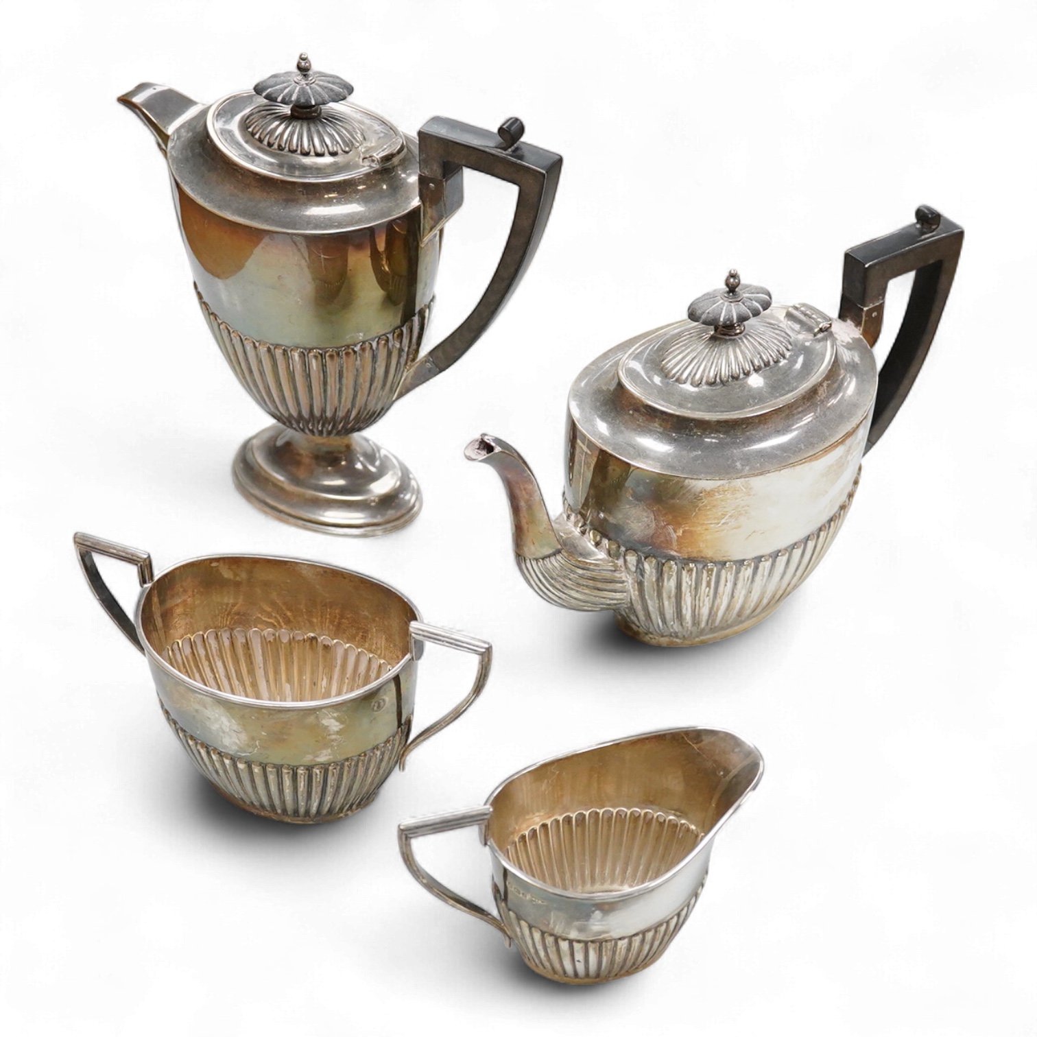 A George V demi fluted silver four piece oval tea set, comprising a teapot, hot water jug, cream jug and sugar bowl, Walker & Hall, 1910/11/12, gross weight 49oz.